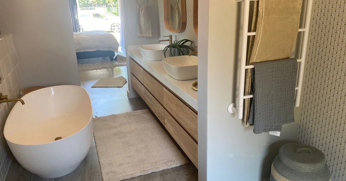 Completed bathroom with timber vanity, twin basins and warm neutral finishes
