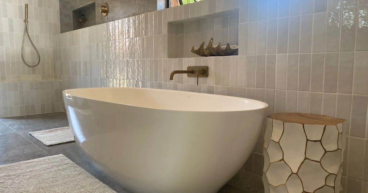 Finished bathroom with freestanding bath beside a tiled walk-in shower