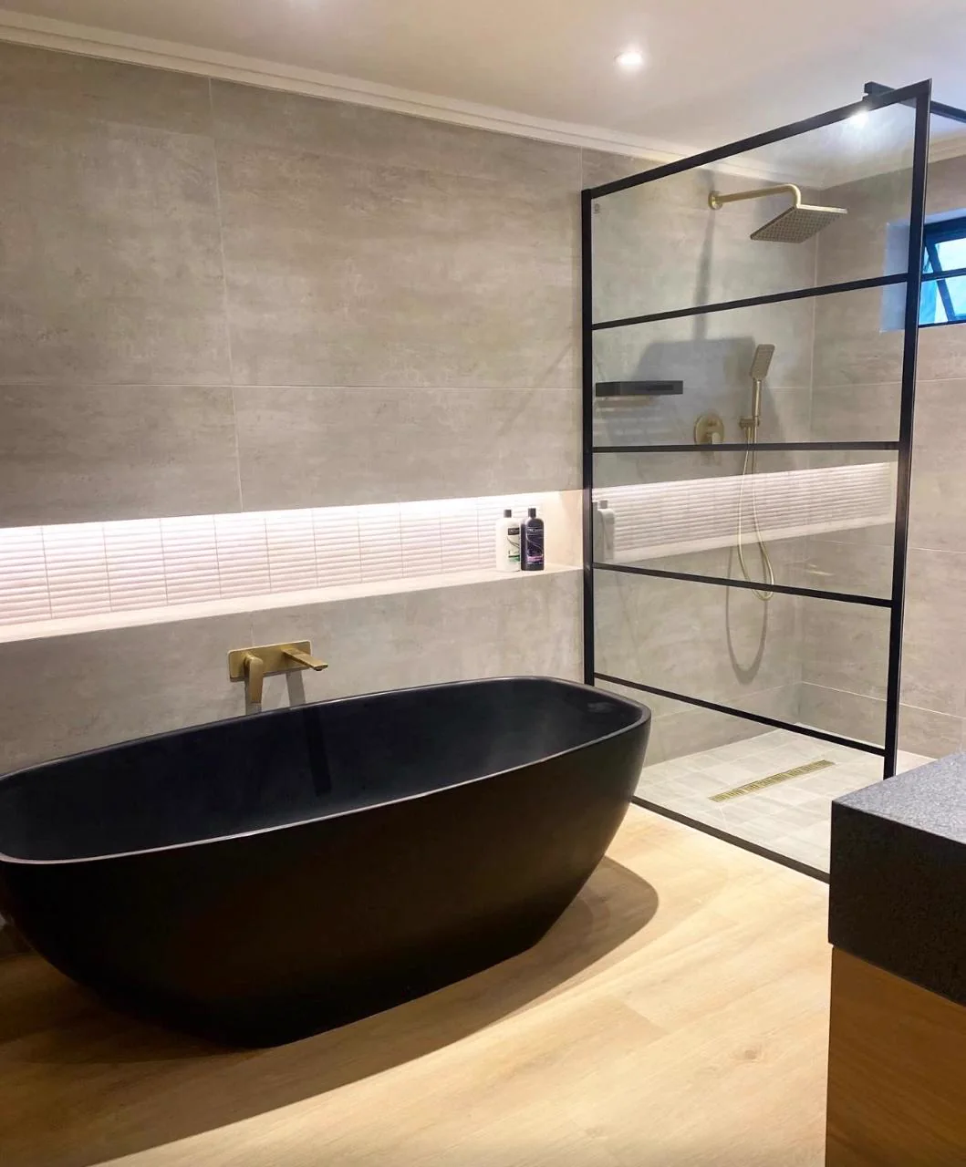 Contemporary bathroom with a black freestanding bath and black-framed glass shower