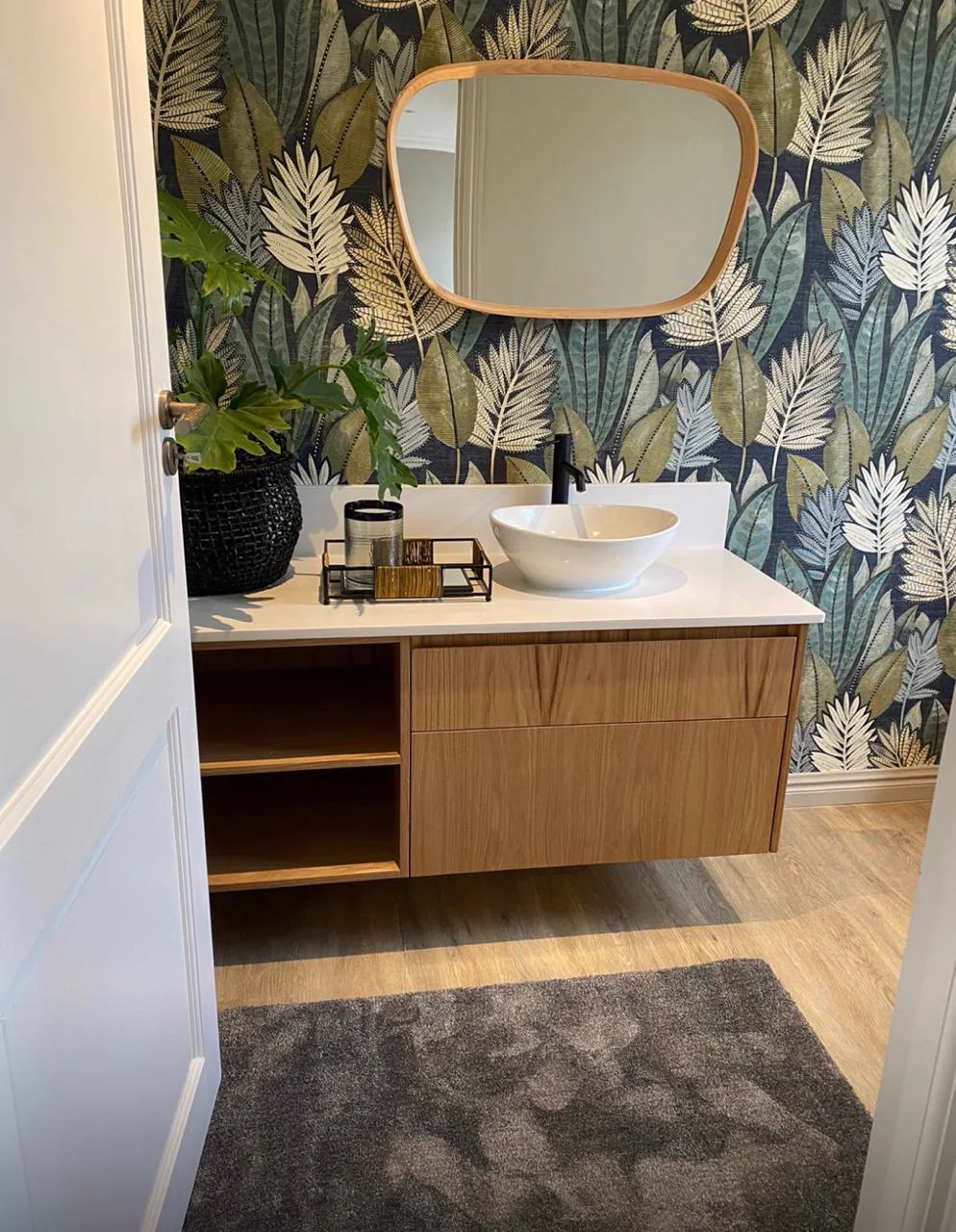 Completed powder room with botanical wallpaper, floating timber vanity and vessel basin
