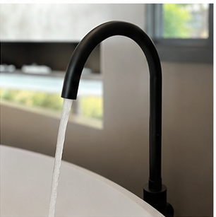 Floor-mounted bath mixer beside a freestanding bath