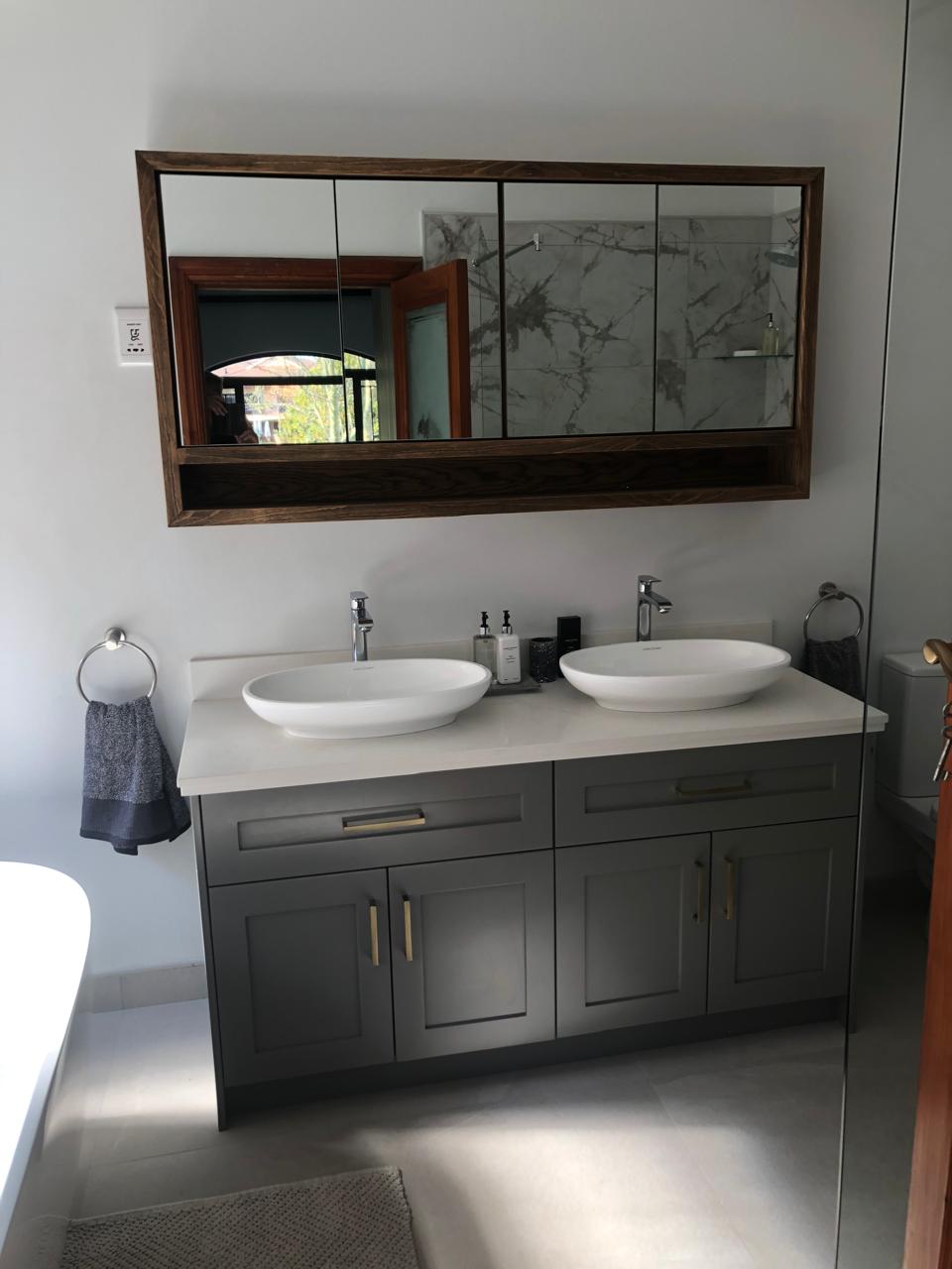 Signature Bathrooms double vanity with two countertop basins and framed mirror