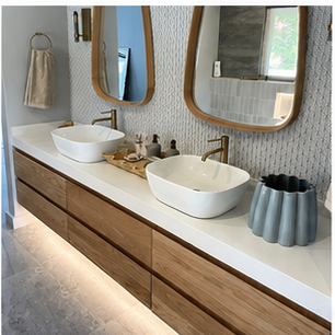 Wide bathroom vanity with multiple drawers and warm brass mixers