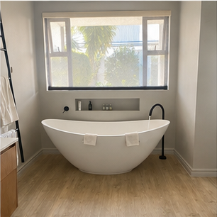 Freestanding bath positioned beside a bathroom window