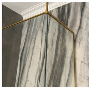 Gold shower enclosure hardware in a luxury bathroom