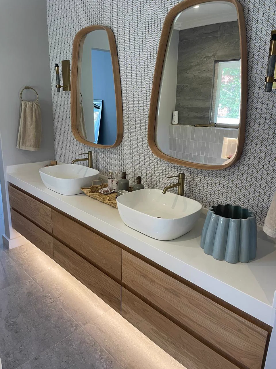 Completed bathroom with a floating timber double vanity, vessel basins and rounded mirrors
